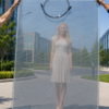 Semi-transparent CdTe BIPV glass panel — view through showing person and building behind the glass, demonstrating transparency